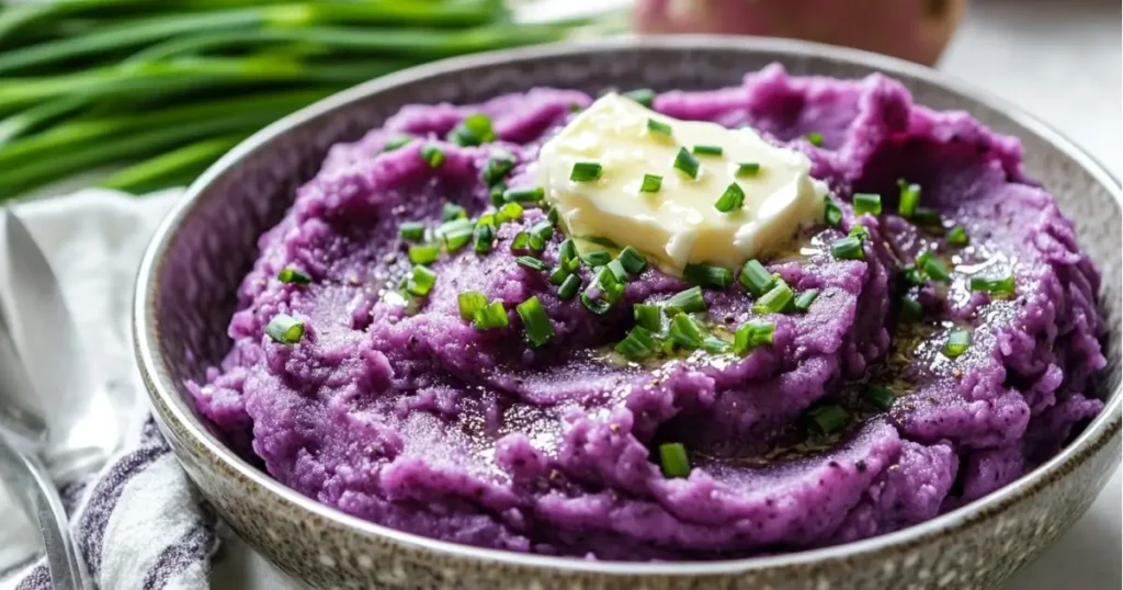 Mashed purple sweet potatoes topped with butter and chives.